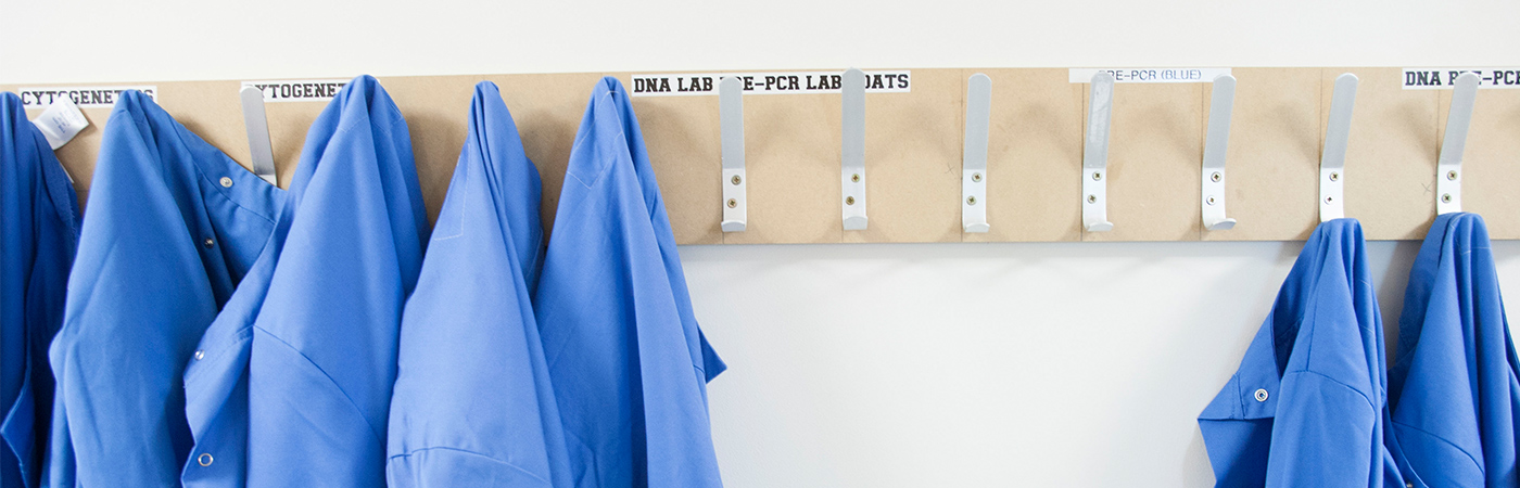 Blue lab coats hanging on pegs